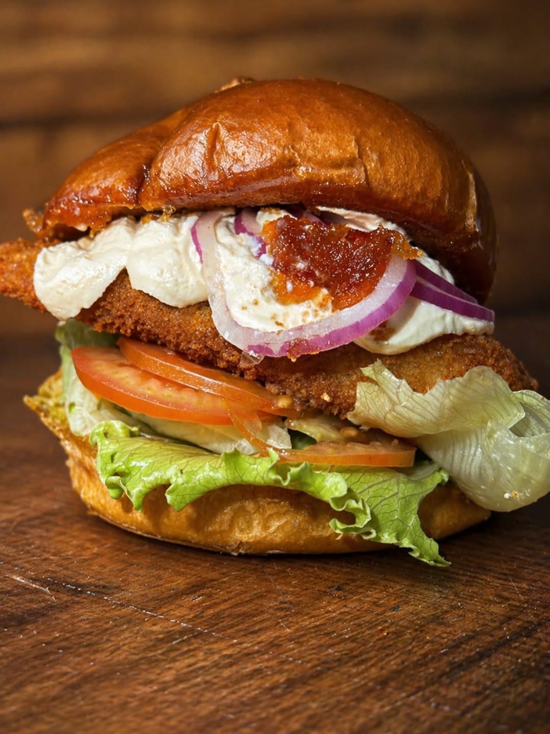 Lanche de frango empanado com cream cheese, geleia de pimenta e salada
